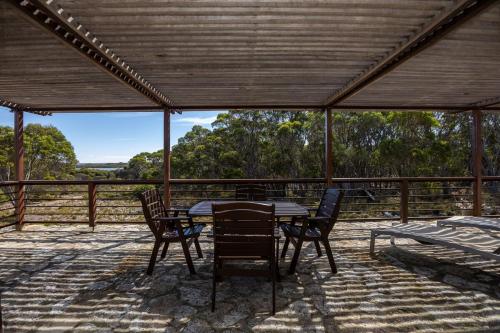 a table and chairs on a patio with a view at Stony Rise Ranch in Pelican Lagoon