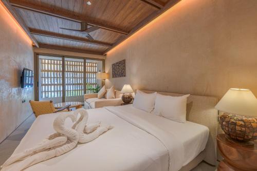 a bedroom with a large bed with two swans on it at Peace House Koh Phi Phi in Phi Phi Islands