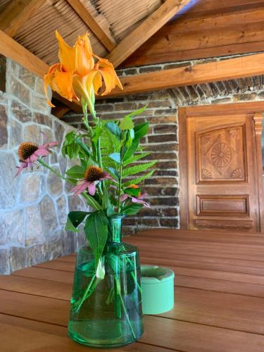 a vase with flowers in it sitting on a table at HolidayHouse Mahova koča in Zreče