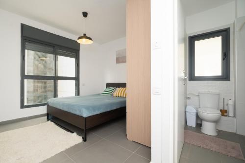 a bedroom with a bed and a toilet at Assuta family in Tel Aviv