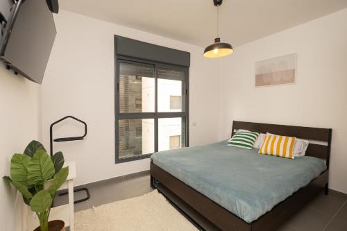 a bedroom with a bed and a window at Assuta family in Tel Aviv