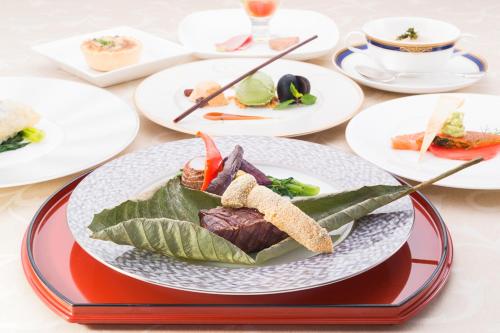 a plate of food on a table with plates of food at Kamikochi Lemeiesta Hotel in Matsumoto