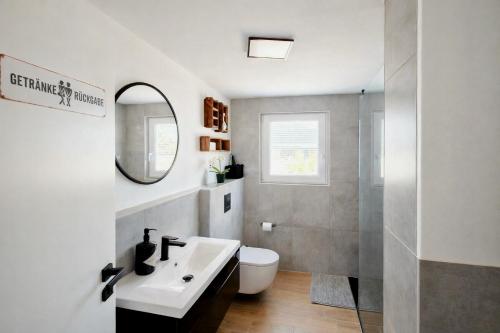 a bathroom with a sink and a toilet and a mirror at Ferienhaus Seeoase - 70qm - Kamin -Terrassen - Parkplatz - Badestelle fußläufig in Joachimsthal