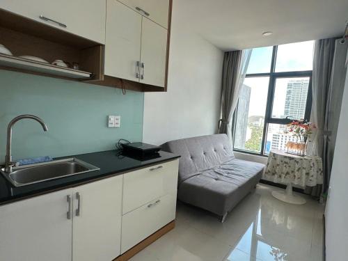 a kitchen with a couch and a sink and a window at Sunrise Sea View Apartment in Nha Trang