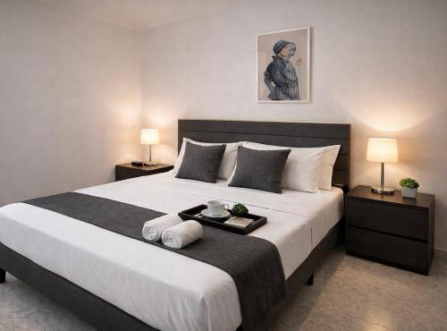 a bedroom with a large white bed with two lamps at The Urban Lodge in Bari