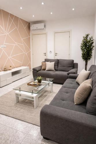 a living room with two couches and a coffee table at The Urban Lodge in Bari