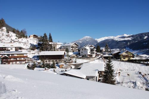 a town covered in snow with mountains in the background at KASSNHOF - Urlaub in den Bergen in Telfes im Stubai
