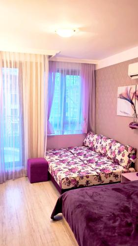 a living room with a couch and a bed at Harmony Suites apartment 4 floor in Sunny Beach