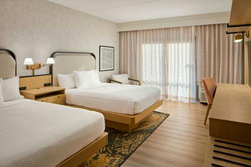 a hotel room with two beds and a window at Courtyard Virginia Beach Norfolk in Virginia Beach