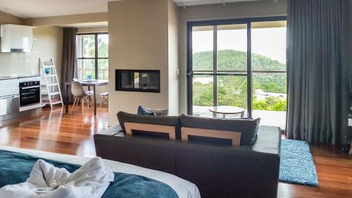 a living room with a couch and a large window at Blue Summit Cottages in Maleny