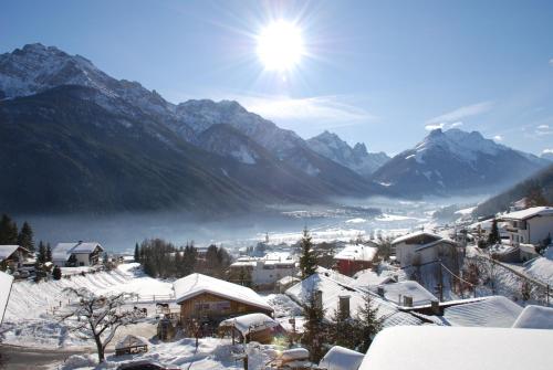 a village covered in snow with mountains in the background at KASSNHOF - Urlaub in den Bergen in Telfes im Stubai