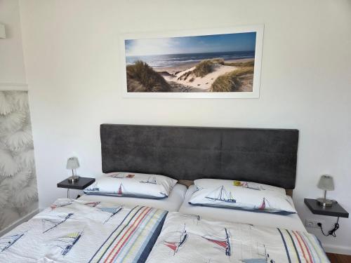 a bedroom with two beds and a picture on the wall at Gästehaus Arkona in Tönning