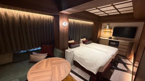 a small bedroom with a bed and a table at Hotel Keihan Asakusa in Tokyo