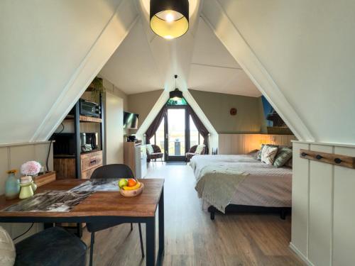 a bedroom with a bed and a table with a bowl of fruit on it at Hotelhuisjes Medemblik in Wieringerwerf