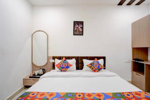 a bedroom with a large bed with a mirror at FabHotel Swastik Villa in Varanasi