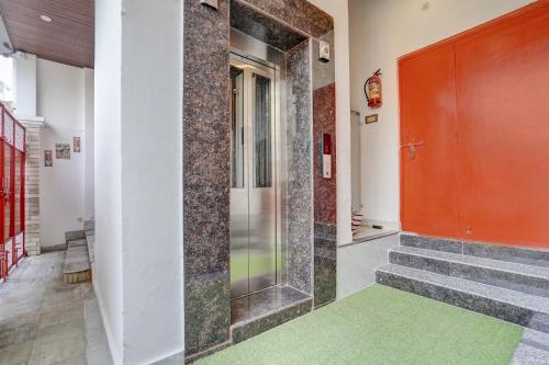 a hallway with a red door and a green rug at FabHotel Swastik Villa in Varanasi
