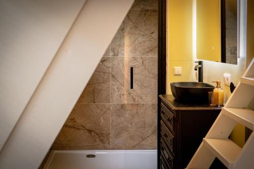 a bathroom with a sink and a shower under a staircase at Boshuisje Rekem - Nirvana in Lanaken
