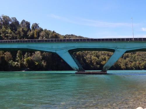 a bridge over a river with a train on it at Cabañas Nutrias Patagonicas in Puelo
