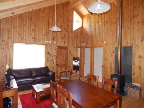 a living room with a table and a couch at Cabañas Nutrias Patagonicas in Puelo
