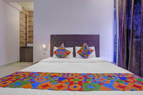 a bedroom with a large bed with a colorful blanket at FabHotel Aaryras Heritage Resort in Mahabaleshwar