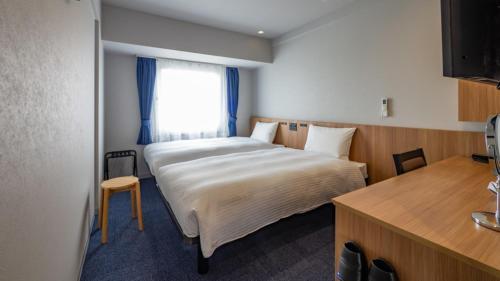 a bedroom with a large bed and a window at Toyoko Inn Kure-eki in Kure