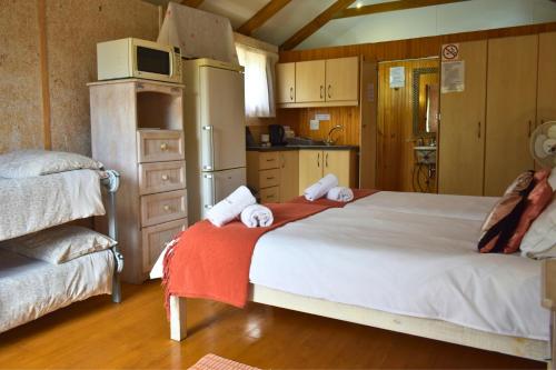 a bedroom with a large bed with towels on it at Dibiki Holiday Resort in Hartenbos