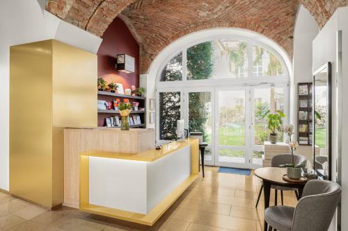 a kitchen with an arched window and a table and chairs at Buda Castle Hotel Budapest in Budapest
