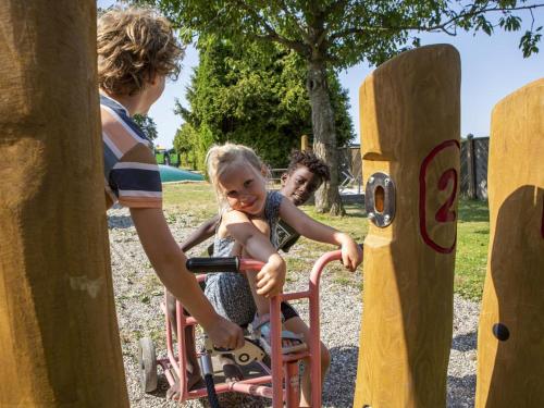 two children playing on a play system at a playground at DCU-Camping Åbyskov Strand in Åbyskov