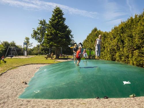 a group of people playing on a green putting green at DCU-Camping Åbyskov Strand in Åbyskov