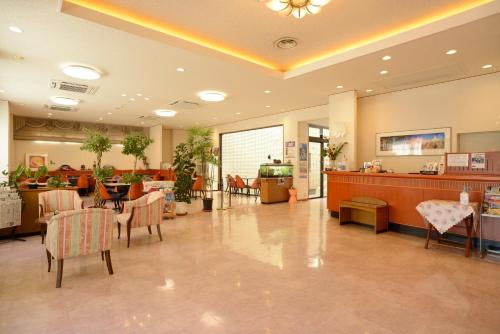 a waiting room with tables and chairs in a hospital at Iki Marina Hotel in Iki