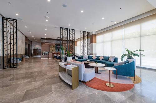 a lobby with blue couches and tables and windows at Belmont Hotel Iloilo in Iloilo City