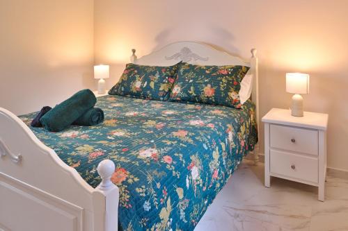 a bedroom with a bed with a floral bedspread at Malanda Falls Retreat in Malanda