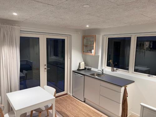 a kitchen with a counter and a sink and windows at Cosy guesthouse in peaceful garden surroundings in Silkeborg