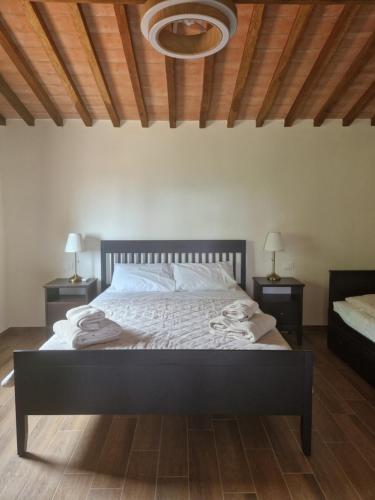 a bedroom with a large bed with two night stands at Casa Lori in Fauglia