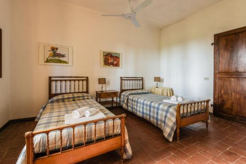 a bedroom with two beds and a ceiling at Podere Magnolia in Pisa