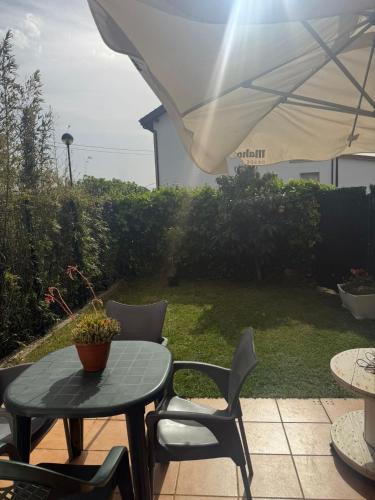 a patio with a table and chairs and an umbrella at El Rincón de Usgo in Miengo