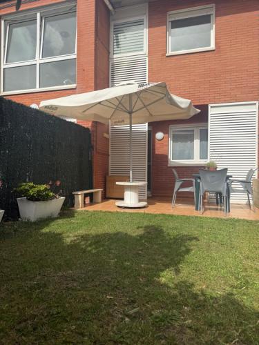 a patio with an umbrella and a table and chairs at El Rincón de Usgo in Miengo