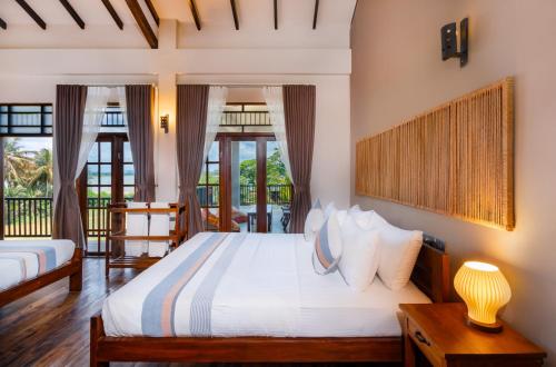 a bedroom with a large bed with white sheets at Serene Park Hotel By Ark in Tissamaharama