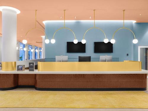 a lobby with a reception desk with two monitors at Hotel Lycium Debrecen - Handwritten Collection in Debrecen
