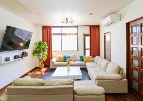 a living room with a couch and a tv at en stay001 in Osaka