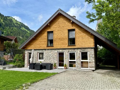 ein Haus mit einer gepflasterten Auffahrt davor in der Unterkunft Alprocks Alvaresort in Bichlbach