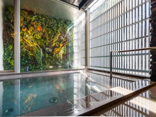 an indoor swimming pool with a view of a garden at Hotel Oak Shizuoka in Shizuoka