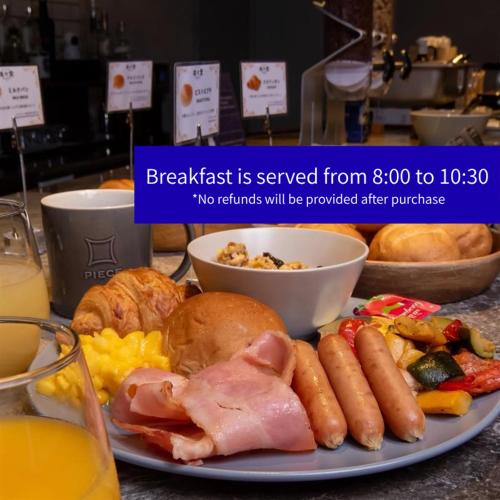 a plate of breakfast food with ham and eggs at Piece Hostel Sanjo in Kyoto