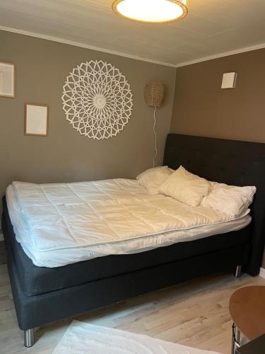 a bed with a black frame and a white comforter at Guesthouse Holmen in Färgelanda