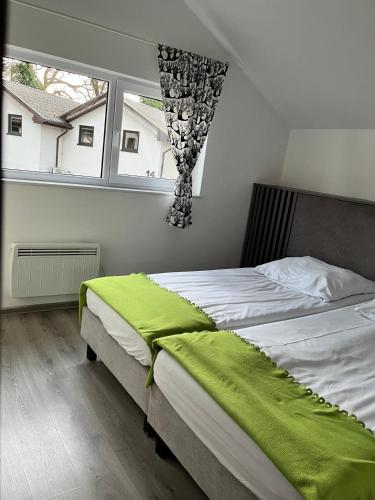 a bedroom with a large bed with a window at Zielony Cypel in Lubniewice