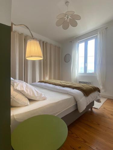 a bedroom with a large bed with a ceiling fan at Maison de vacances, centre ville Gambetta in La Teste-de-Buch