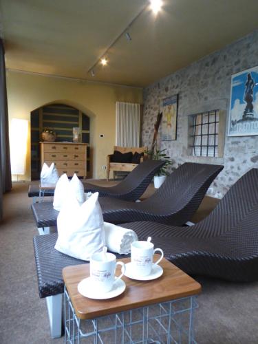 une pièce avec des chaises et des tasses à café sur des tables dans l'établissement Hotel Andreas Hofer, à Egna