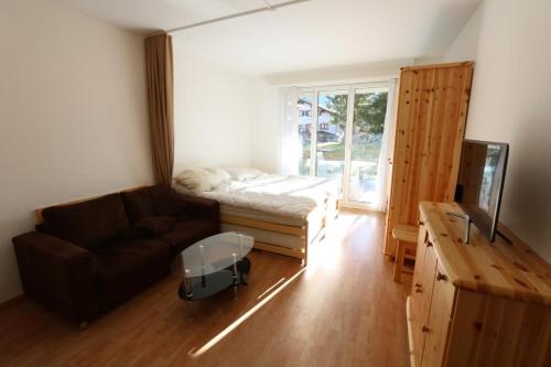 a living room with a couch and a bed at Apartment Bünda in Davos