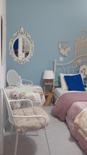 a bedroom with blue walls and a bed and a mirror at Studio Despoina in Skala Kallonis