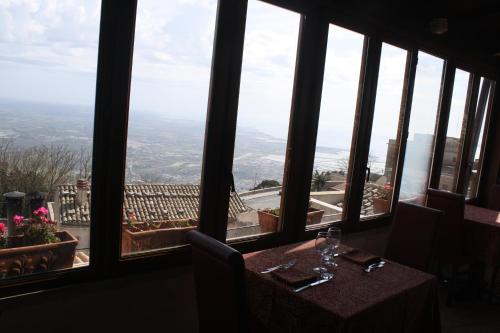a table in a restaurant with a view of the city at Hotel Elimo in Erice